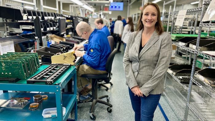 Lady standing in front of the lens in a factory