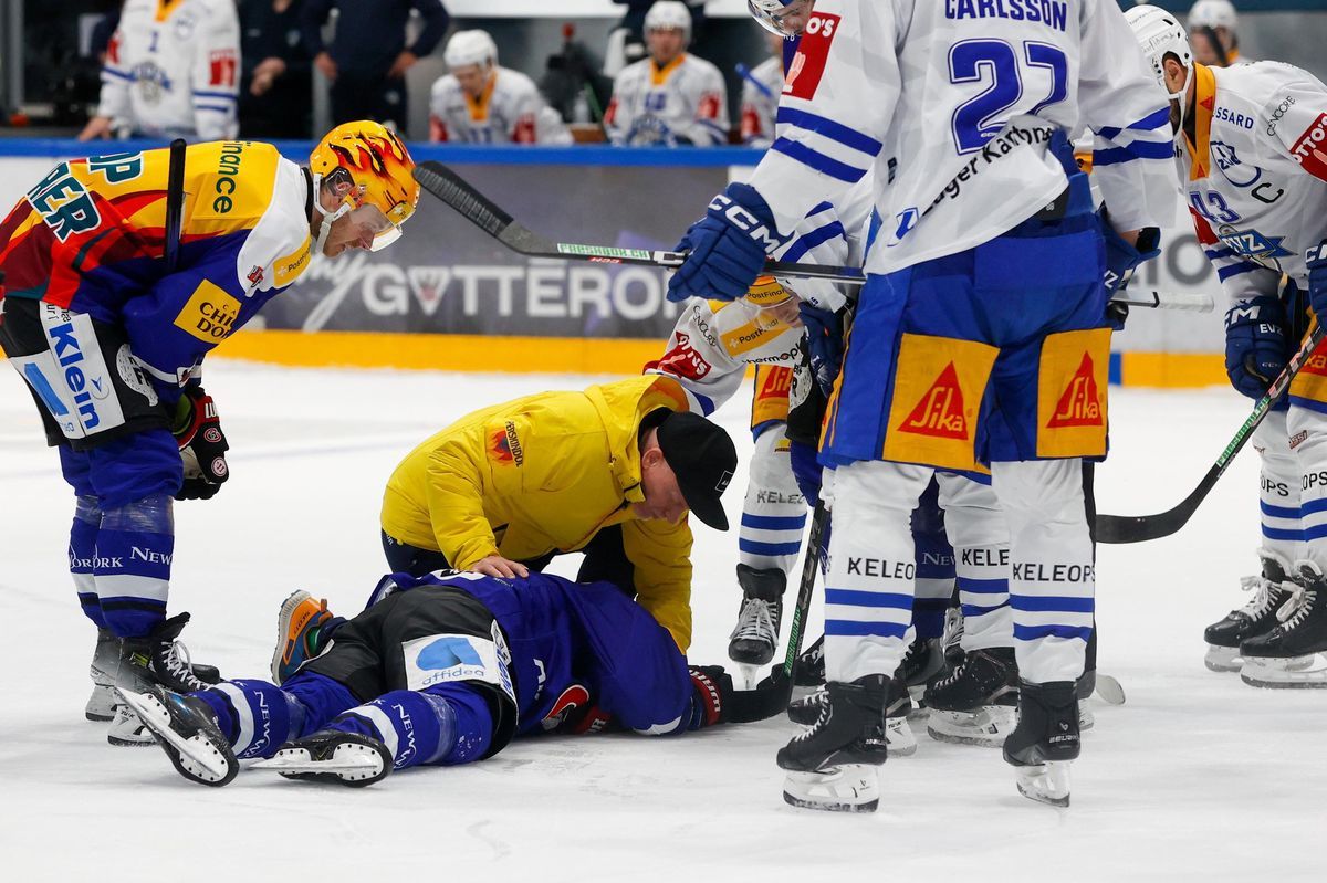 Ice hockey player Maximilian Friborg Stale lying on the injured ice, surrounded by teammates and a nurser in a match against EV Zug. Ice hockey player Maximilian Friborg Stale lying on the injured ice, surrounded by teammates and a nurser in a match against EV Zug.