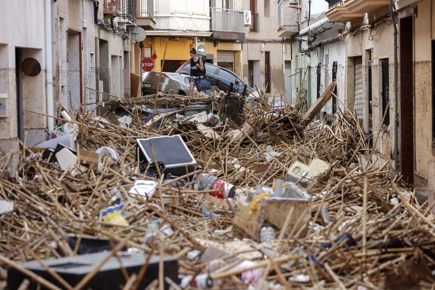 epa11692837 A resident walks over debris in the flood-hit municipality of Paiporta, in the province of Valencia, Spain, 30 October 2024. The intense rainfall impacting the eastern part of the country ...