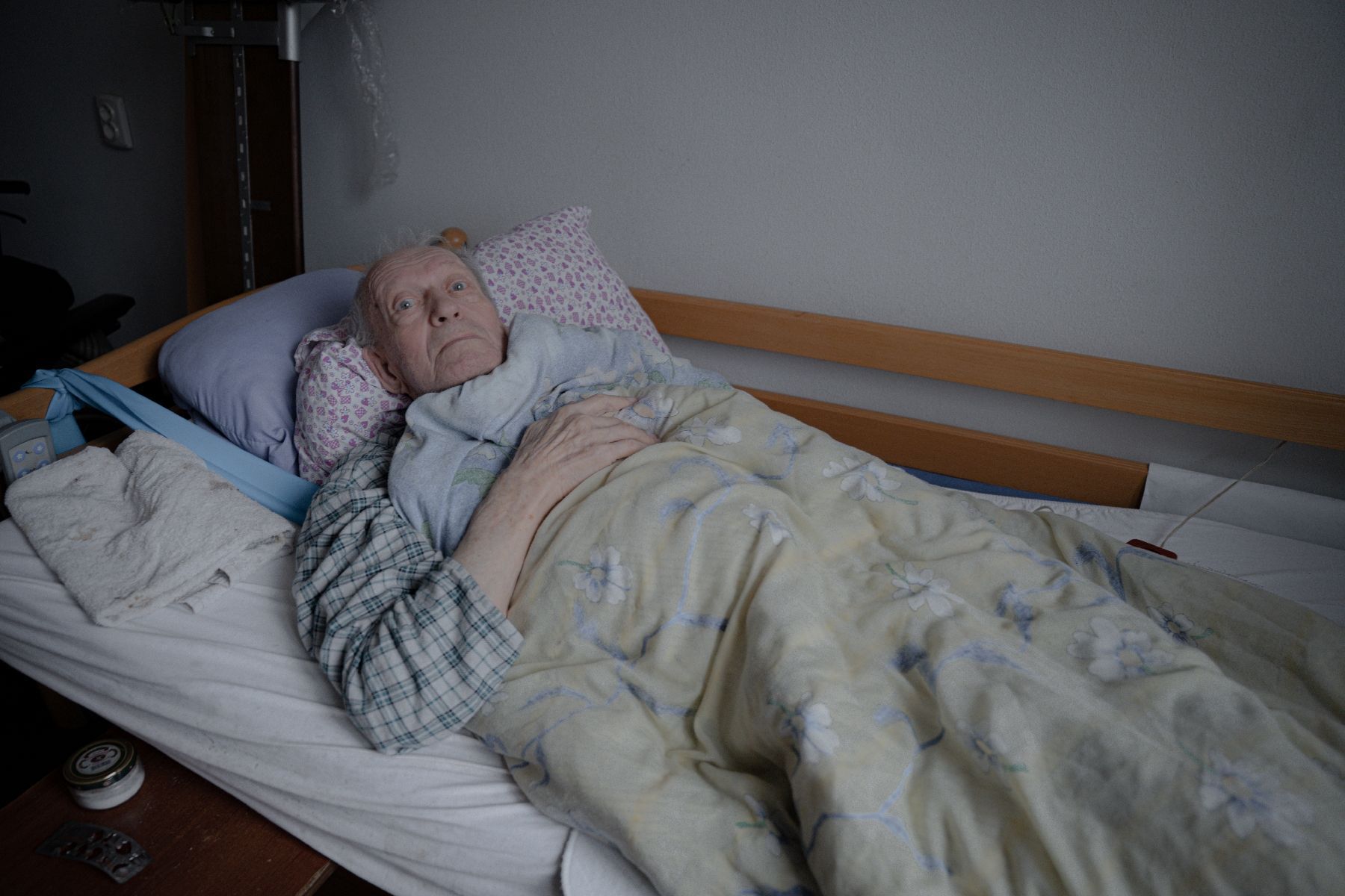 Iouriï Miagra is bedridden in his room, in a shelter for seniors in Kharkiv, Ukraine, March 26, 2025