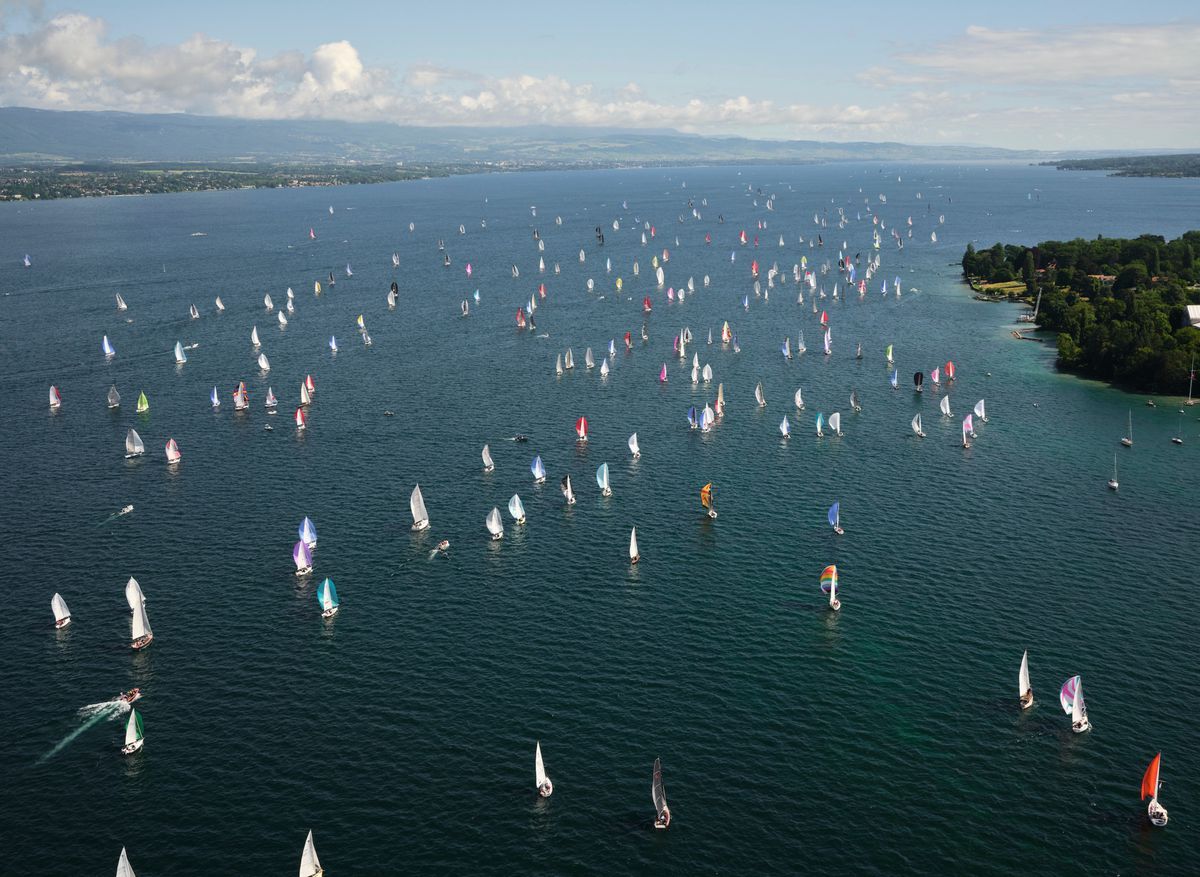 Aerial view of a regatta with many colored sailboats on Lake Geneva, on a sunny day. Aerial view of a regatta with many colored sailboats on Lake Geneva, on a sunny day.