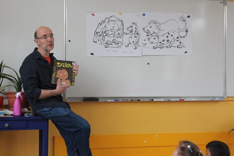 Jean-Charles Sarazin presents the Sassou book to CP students.