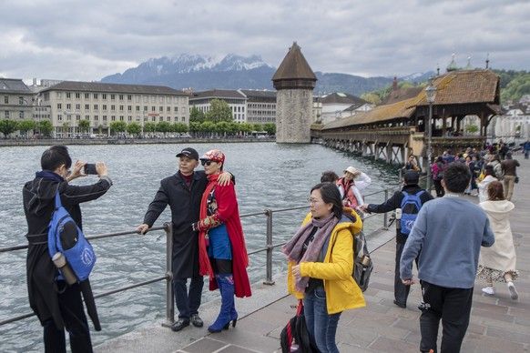 Tourists of the 4 ' 000 large Chinese tour group of the cosmetic company & quot; Jeunesse Global & Quot; Pull through the city of Lucerne and visit the Kapellbruecke on Monday, 13 ...
