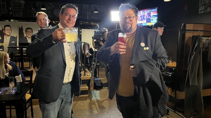 The two men hold a glass of beer in the Blue Lion Brasserie of Alma.