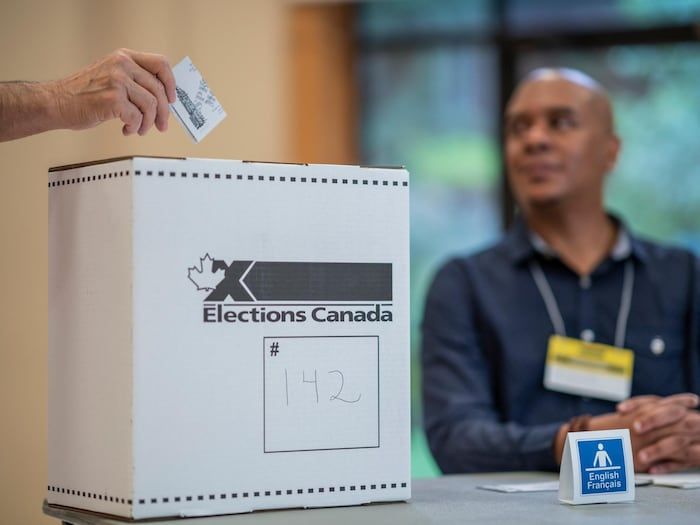 A person drops off their ballot in an urn.