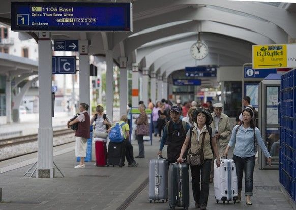 Asian tourists are waiting for the train on Saturday, August 6, 2011, in Interlaken West. The strong Swiss franc takes care of the tourism industry and hits the tourists away. (Keystone/Peter Sch ...