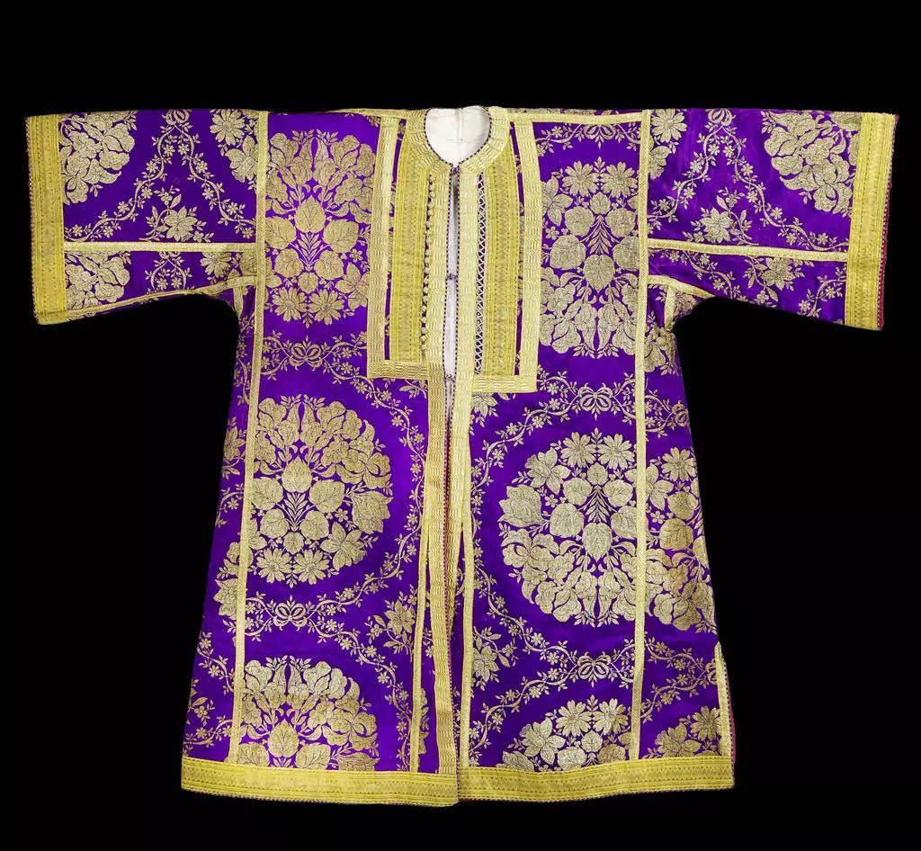 Traditional clothing richly decorated with golden floral patterns on a purple background. Traditional clothing richly decorated with golden floral patterns on a purple background.