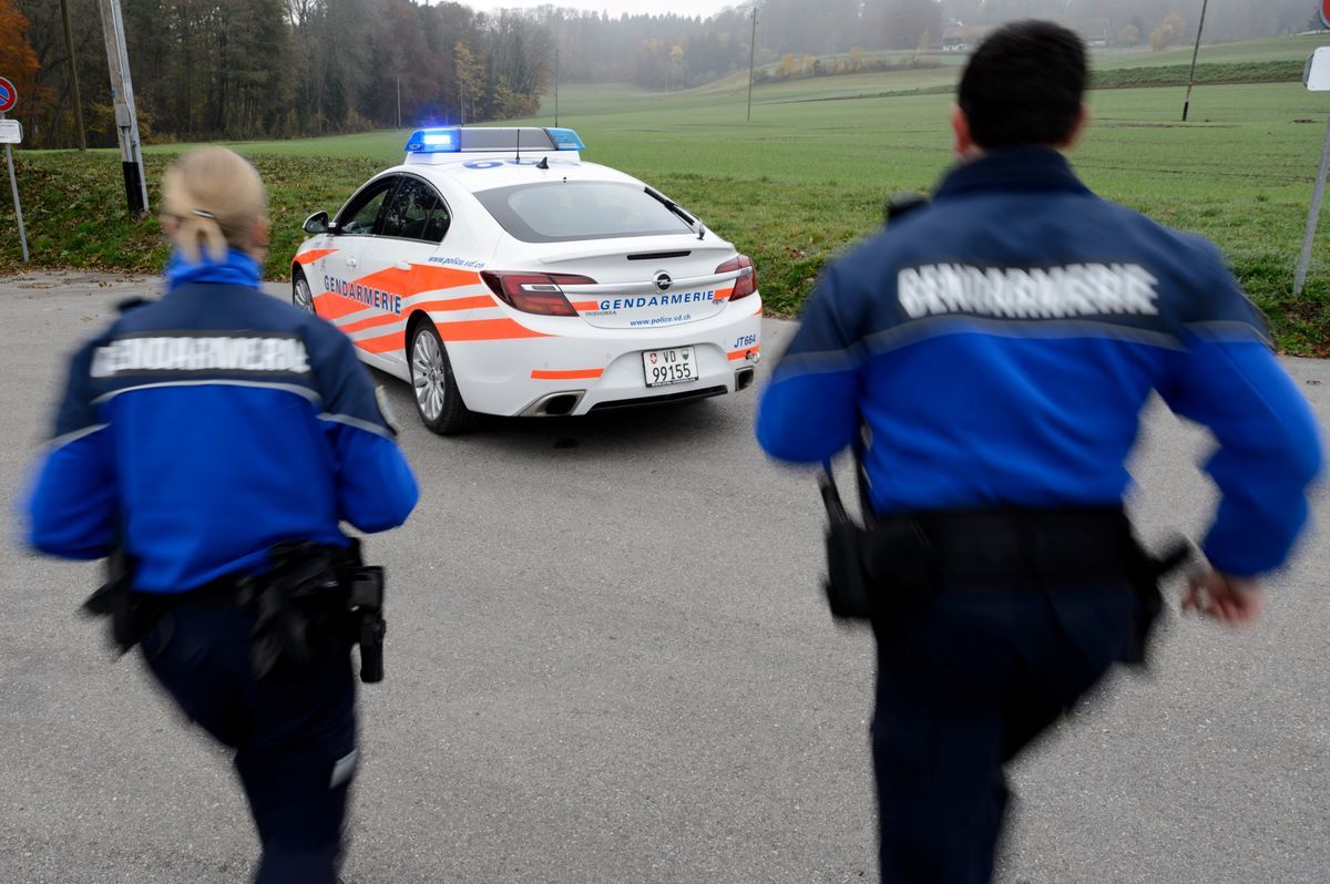 Vaud cantonal police gendarmes run near a police car in Cugy, Vaud, November 3, 2015. Vaud cantonal police gendarmes run near a police car in Cugy, Vaud, November 3, 2015.