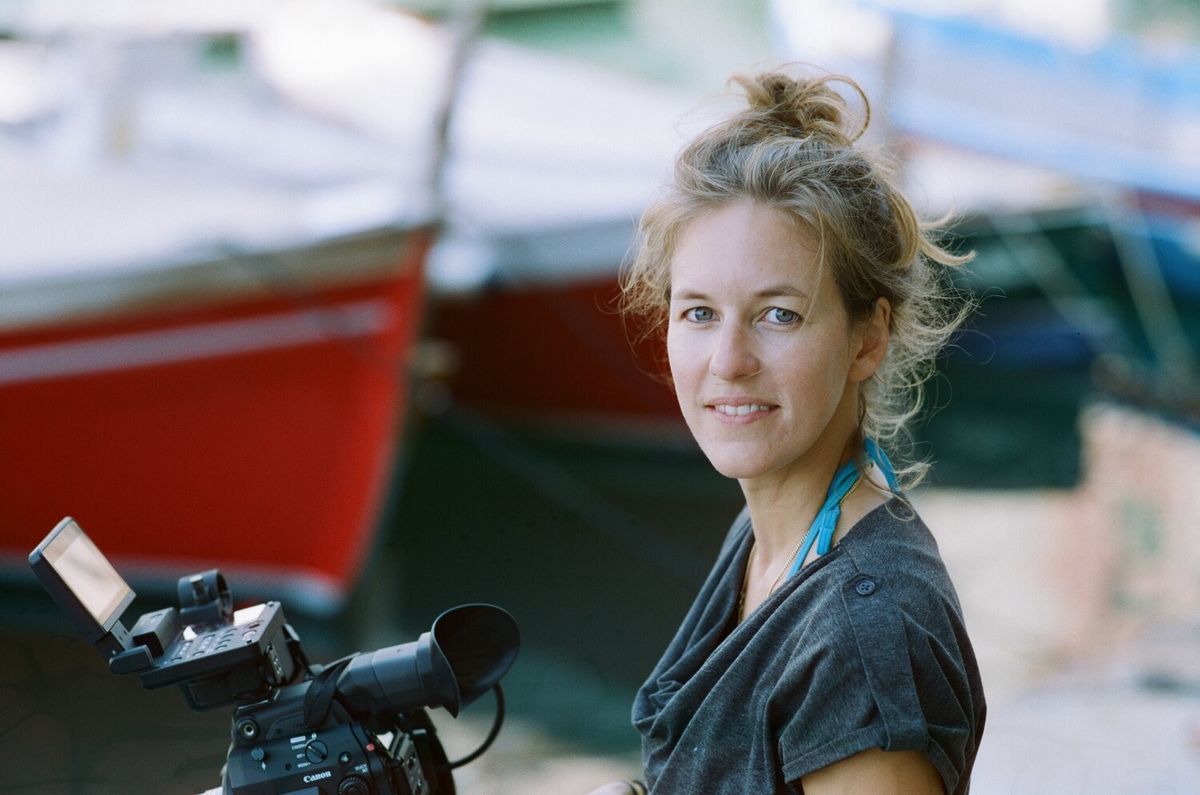 Woman with a camera, bottom of blurred colored boats. Woman with a camera, bottom of blurred colored boats.