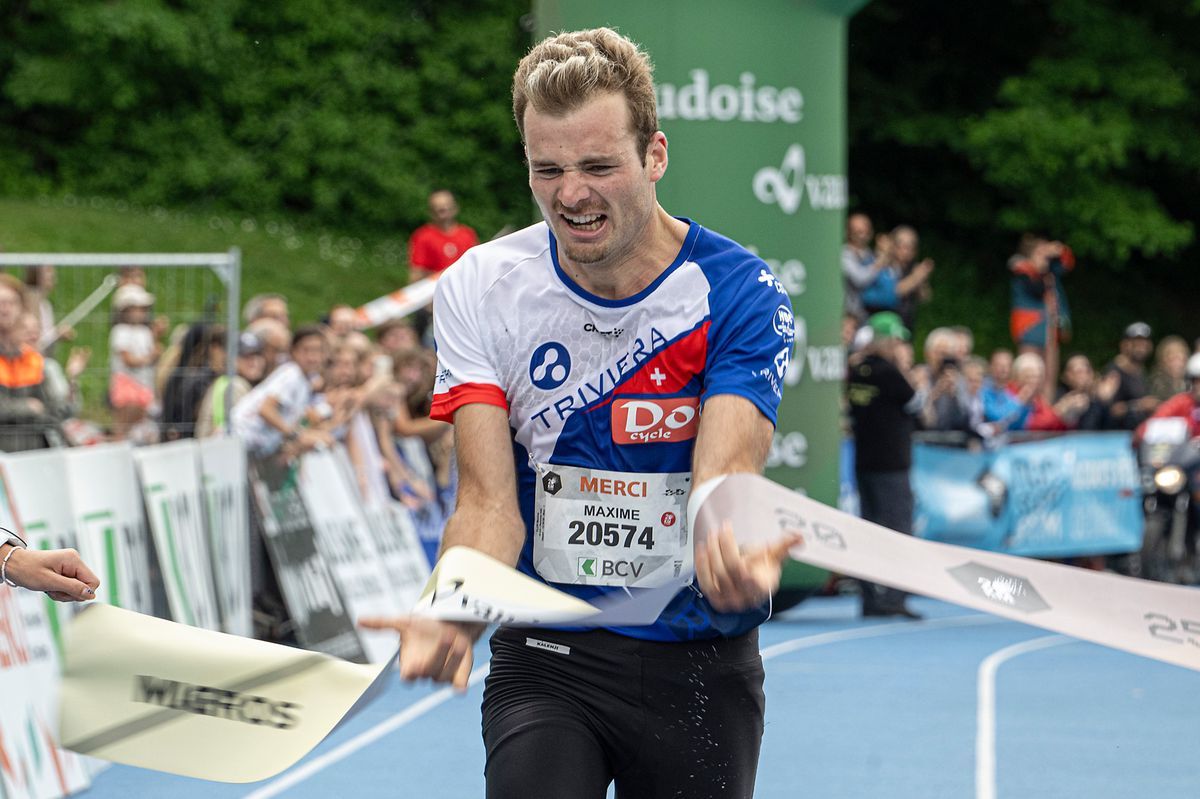 A runner crossing the finish line during a race with a bib 'Thank you Maxime 20574', surrounded by applauding spectators. A runner crossing the finish line during a race with a bib 'Thank you Maxime 20574', surrounded by applauding spectators.