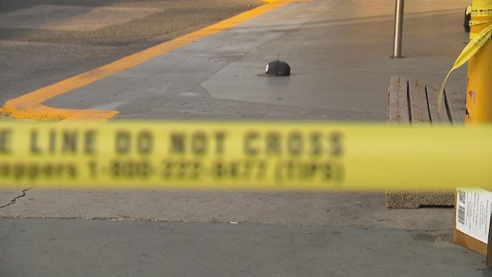 A cap behind a yellow ribbon on a crime scene.