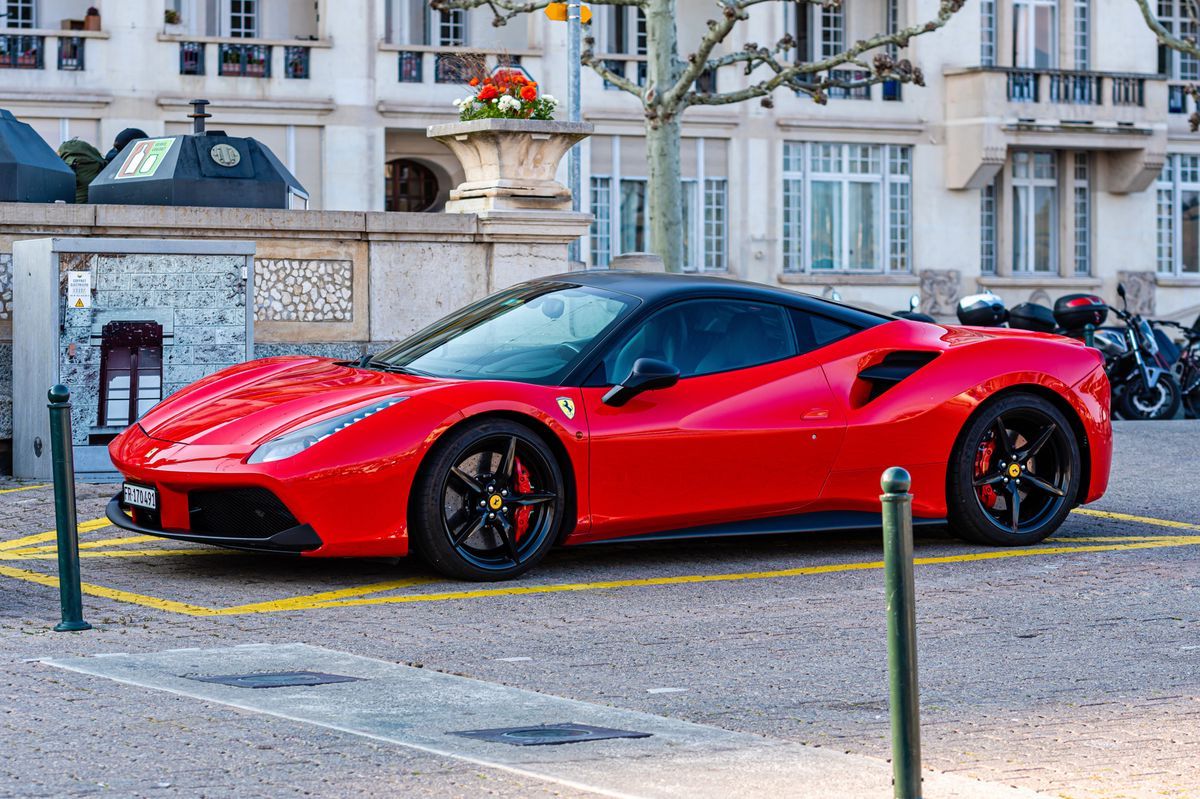 Luxury red sports car parked on the promenade in Geneva, Switzerland, April 14, 2019. Luxury red sports car parked on the promenade in Geneva, Switzerland, April 14, 2019.