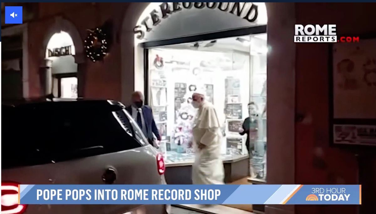 The pope leaves a record store in Rome, accompanied by a man at night. Visible The pope leaves a record store in Rome, accompanied by a man at night. Visible