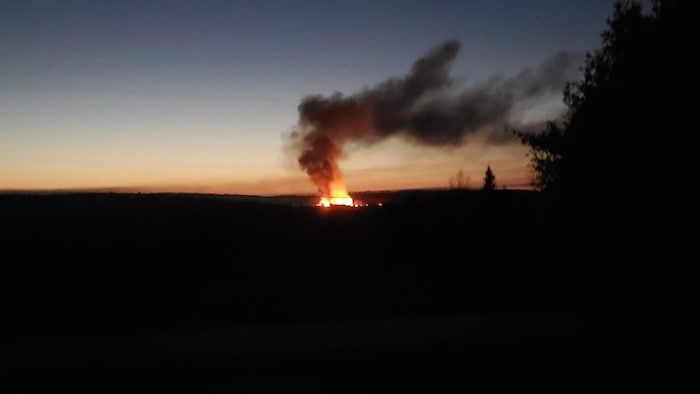 A plume of smoke and a blaze in the distance.