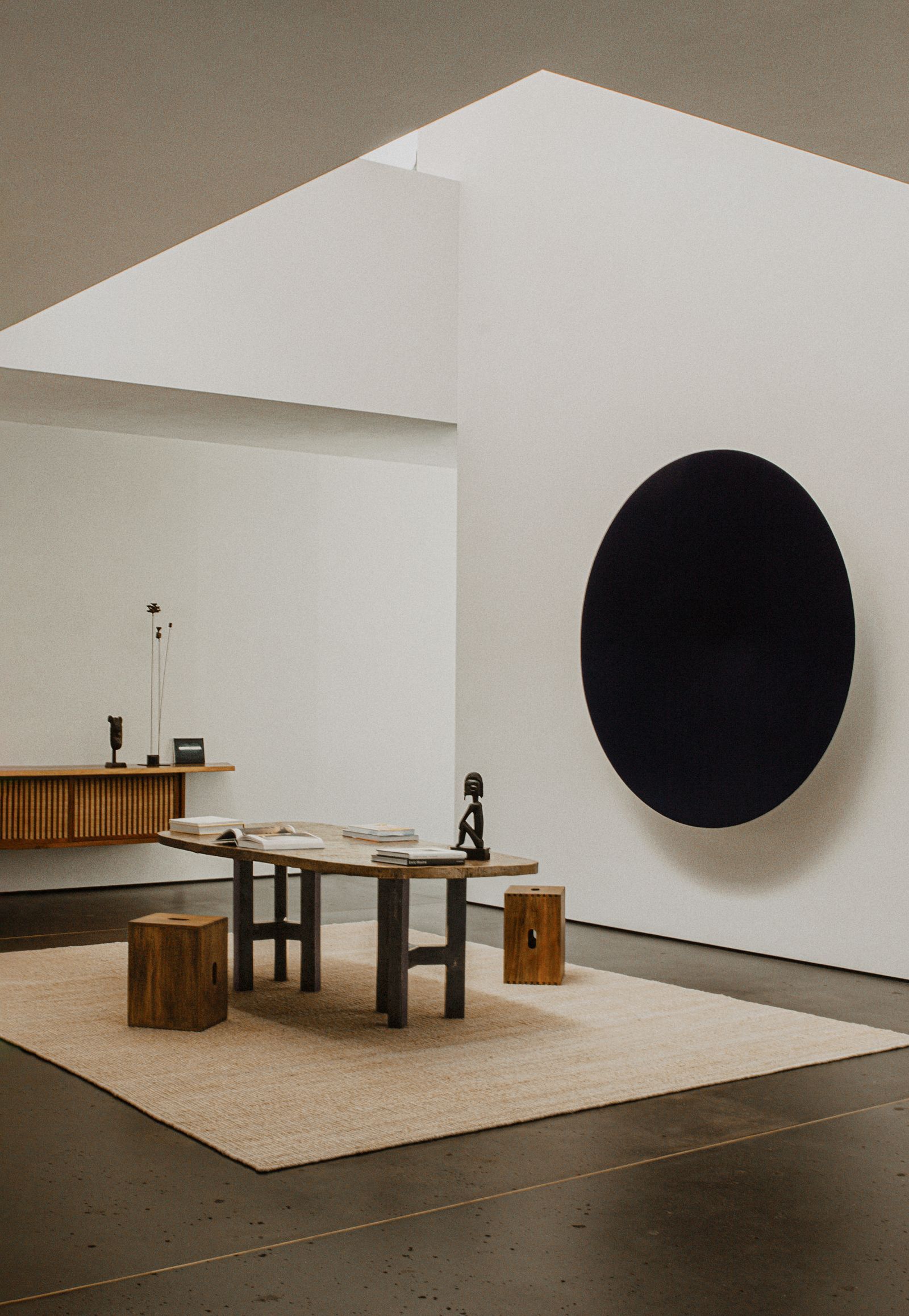 Black work by Anish Kapoor in a minimalist beige living room