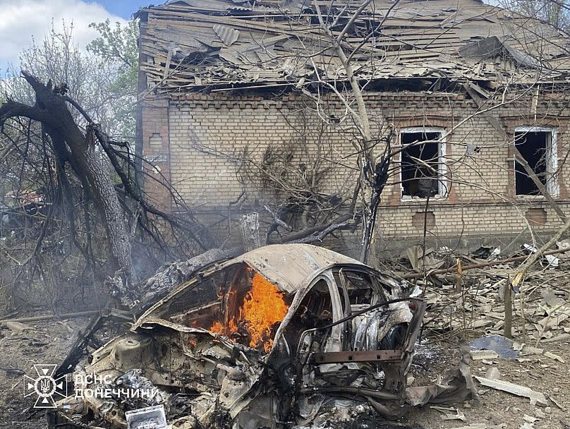 A car on fire in front of a house destroyed by a Russian air raid in the Donetsk region on April 28, 2025.