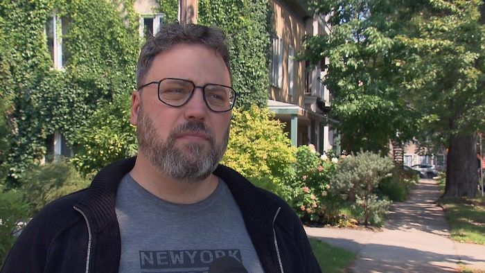 Raymond Poirier grants an interview outside, in the Limoilou district, in summer.