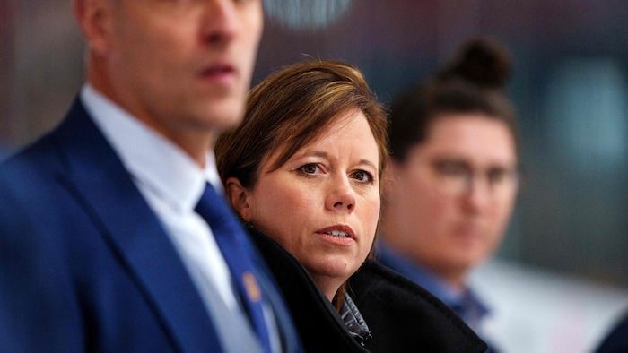 A hockey coach looks at the action during a match.