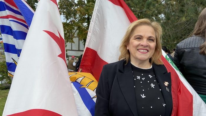 A woman in front of flags.