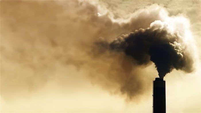 A tower rejects a large amount of smoke into the atmosphere.