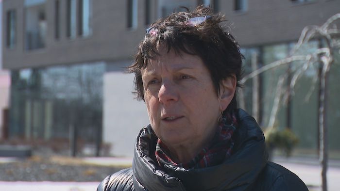 A woman looks at the camera outside.