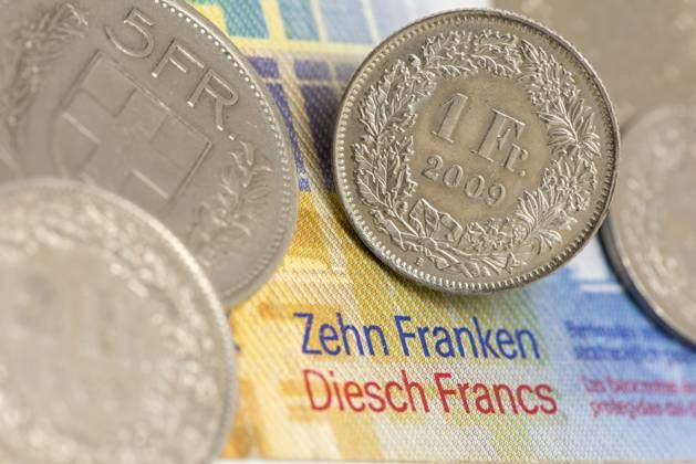 A piece of 1 Swiss francs placed on a 10 Swiss ticket with other parts in the background. A piece of 1 Swiss francs placed on a 10 Swiss ticket with other parts in the background.