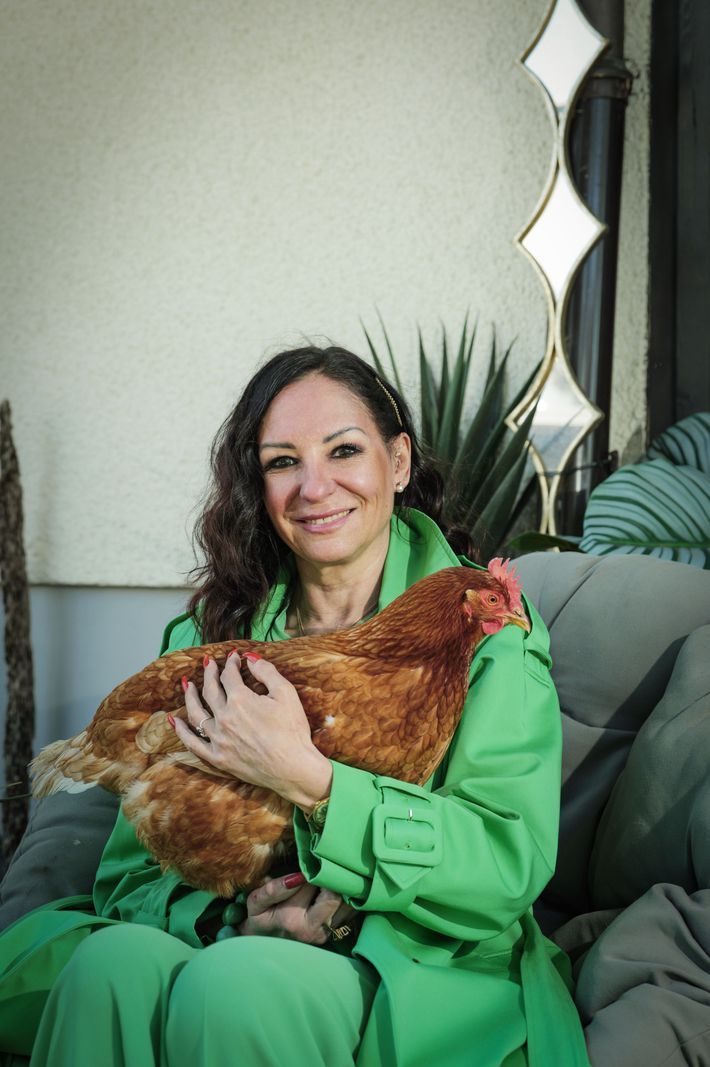 Caroline Verneret holding Marguerite, a hen, in Geneva, on March 31, 2025, dressed in a green coat. Caroline Verneret holding Marguerite, a hen, in Geneva, on March 31, 2025, dressed in a green coat.
