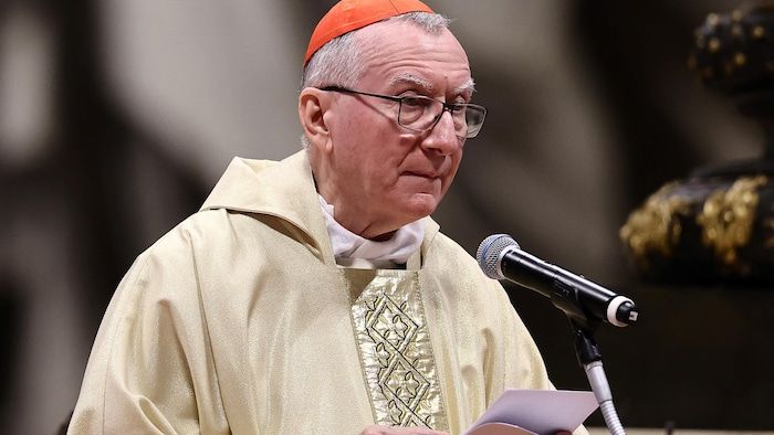 A man celebrates a mass in front of a microphone.