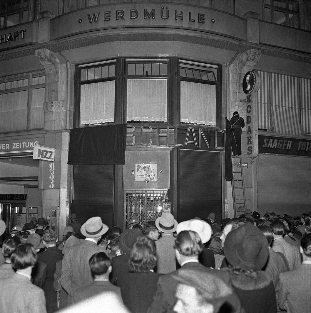 Human crowd in front of the German transport office on Zurich Bahnhofstrasse on the evening of May 8, 1945. The lettering 'Germany' is imposed black. Human crowd in front of the German transport office on Zurich Bahnhofstrasse on the evening of May 8, 1945. The lettering 'Germany' is imposed black.