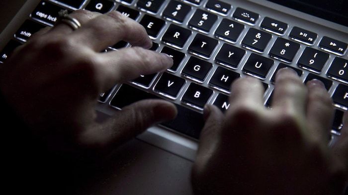 Hands on a computer keyboard.