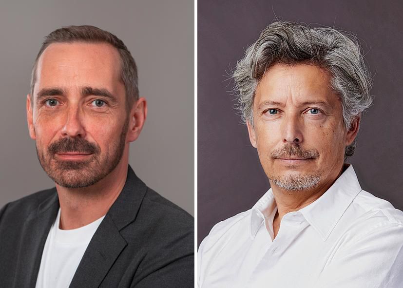 Two men posing against a neutral background, one in a dark jacket and the other in a light shirt, in Lausanne, October 2021.