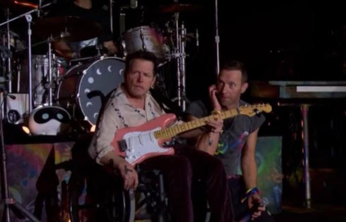 Michael J. Fox arrives on stage in a wheelchair to perform with Coldplay in concert