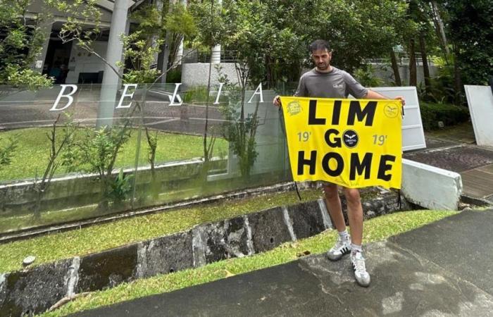 two supporters on their honeymoon draw banners against Peter Lim in Singapore… and end up in detention