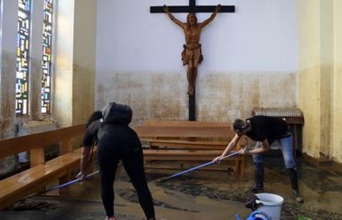 a crowd of volunteers are busy cleaning up the disaster-stricken towns near Valencia