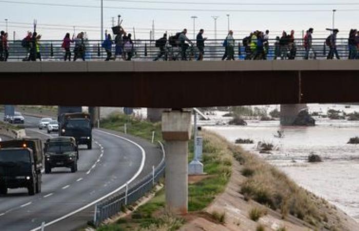 a crowd of volunteers are busy cleaning up the disaster-stricken towns near Valencia