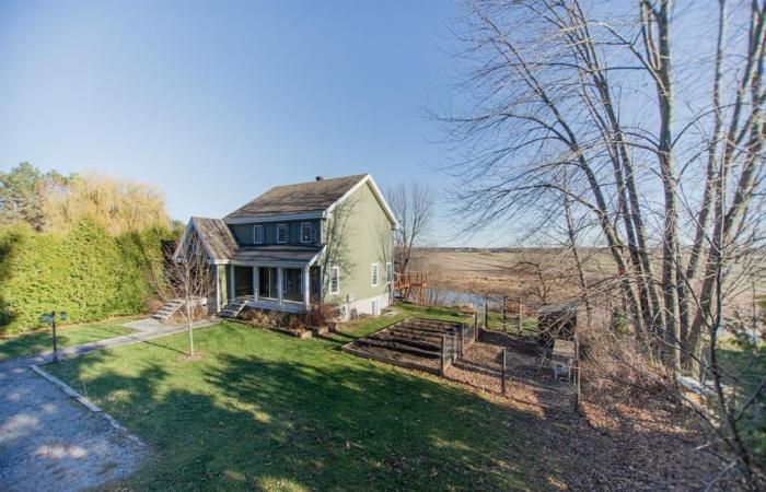 Elegant cottage bordering a body of water against a backdrop of rural tranquility