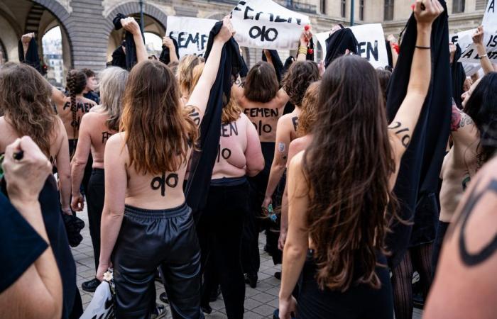 Femen activists demonstrate in front of the Louvre pyramid