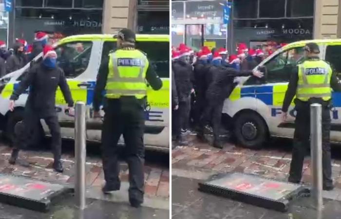 Masked Rangers fan squares up to police before punching van as huge group of ultras in SANTA HATS march to Celtic game