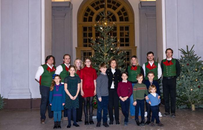 Surrounded by her grandchildren, Silvia from Sweden receives Christmas trees