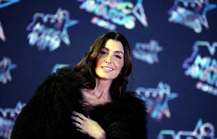 Wrapped up in a big woolen coat, Jenifer strikes a pose under the Eiffel Tower in a white suit