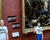 at the Louvre, Food Response activists stick posters near the painting “Liberty leading the people”
